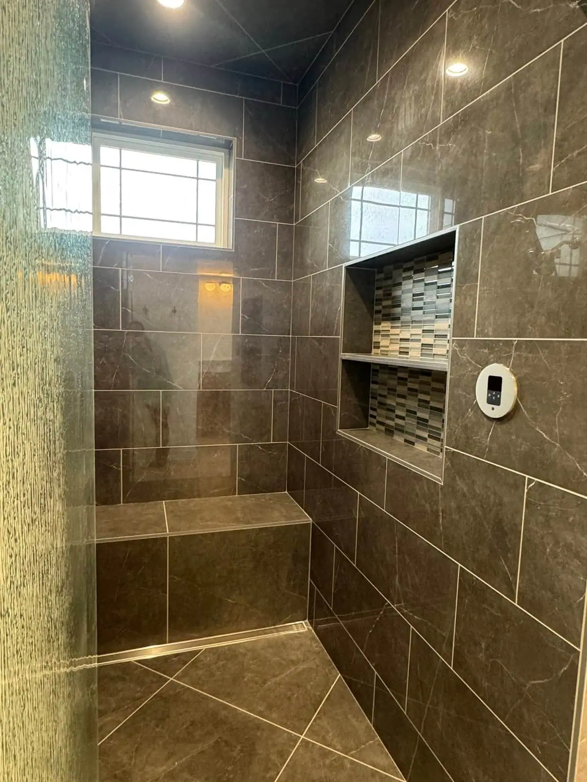 Slate-tiled walk-in shower with a built-in bench