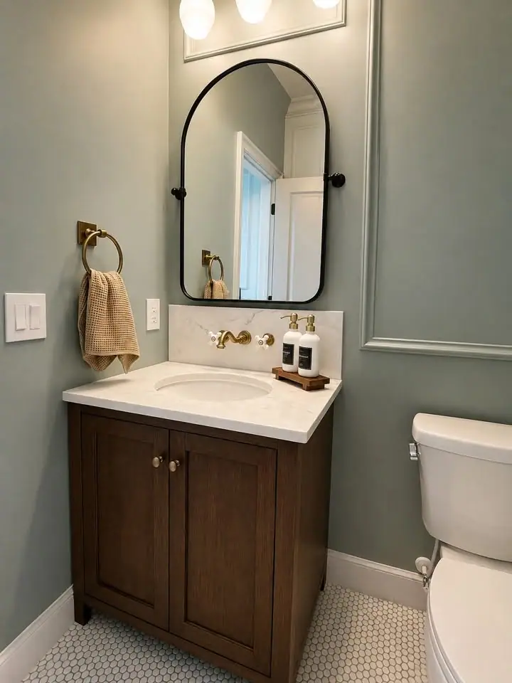 Powder bath with wood vanity, white countertop, and arched mirror
