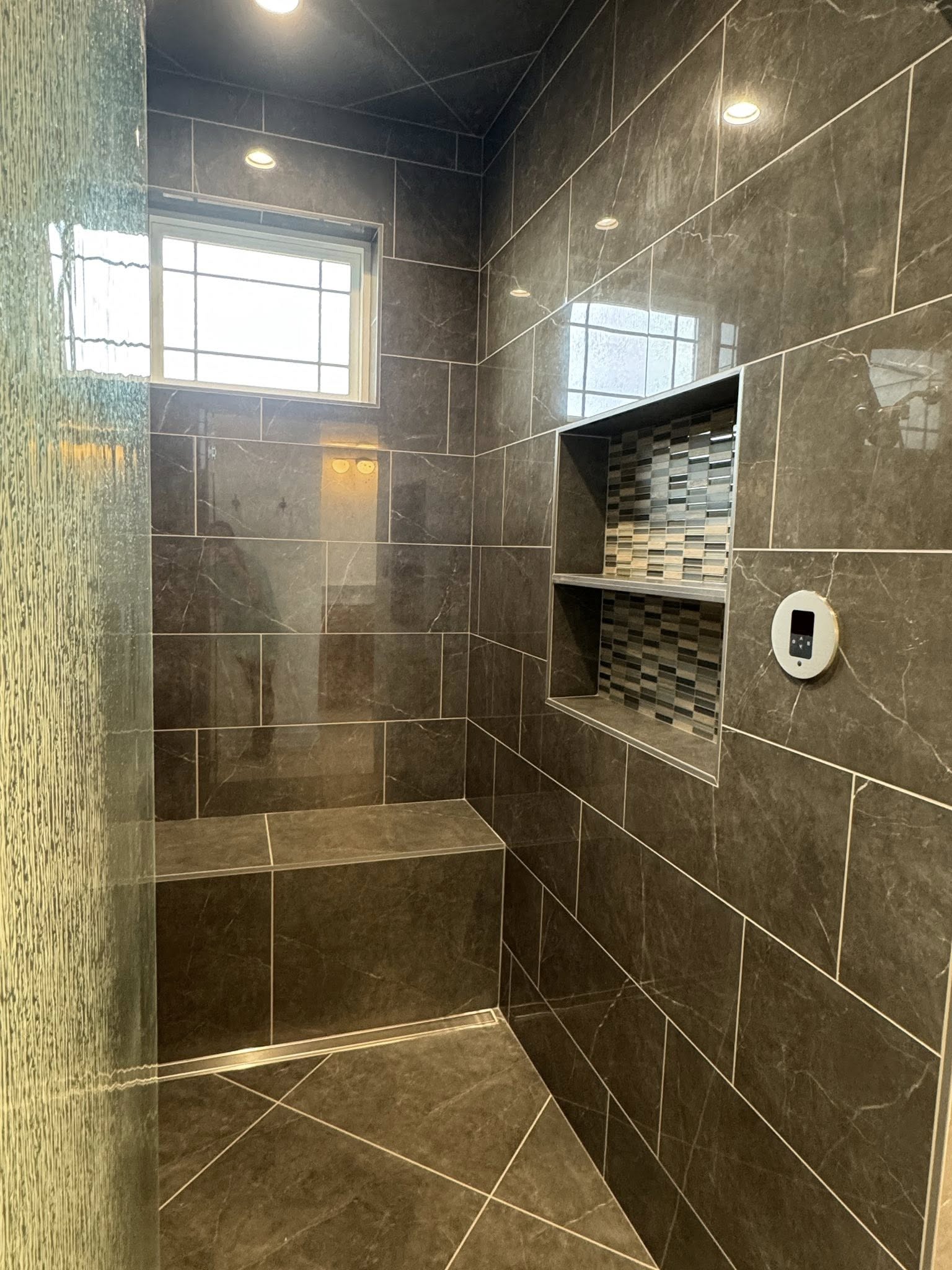 Slate-tiled walk-in shower with a built-in bench